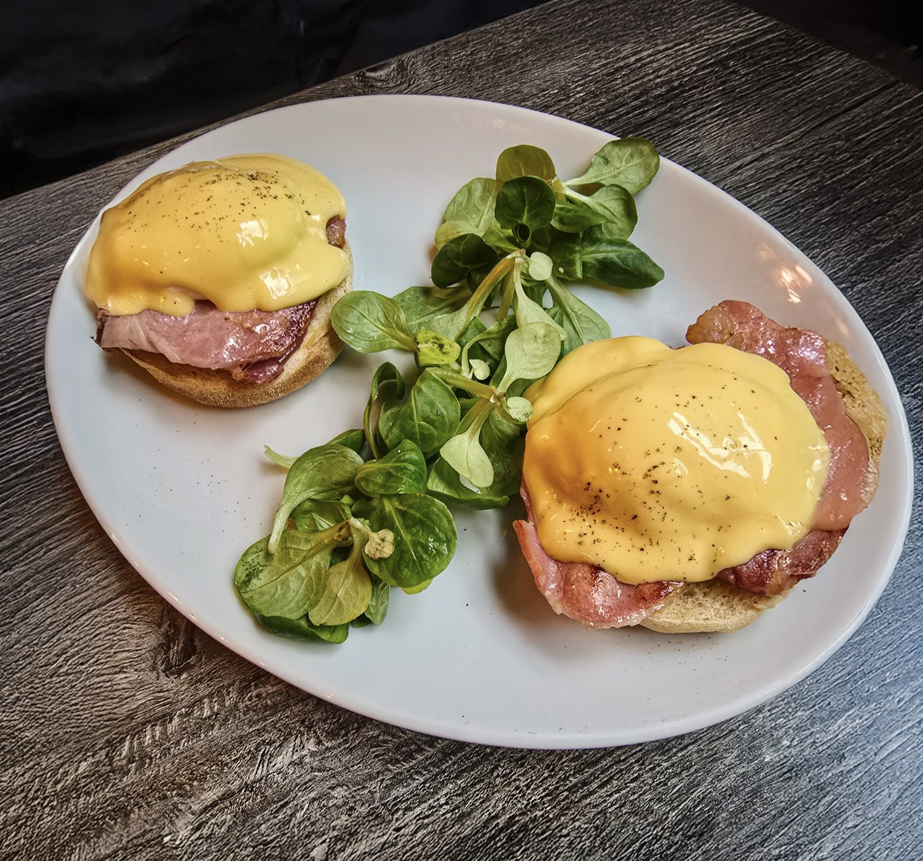 Eggs Benedict with hollandaise and a pea-shoot salad