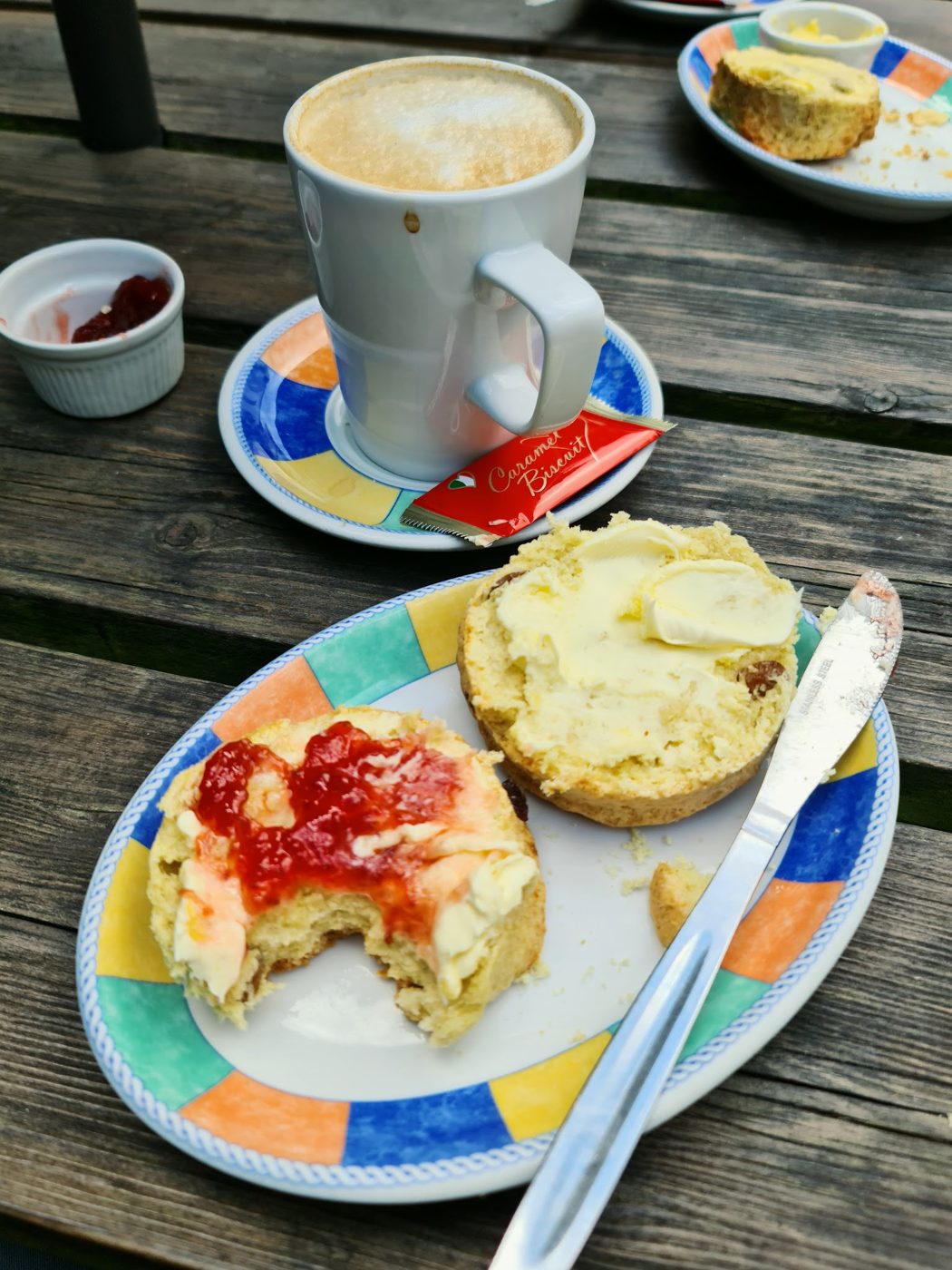A scone with jam and a cup of coffee